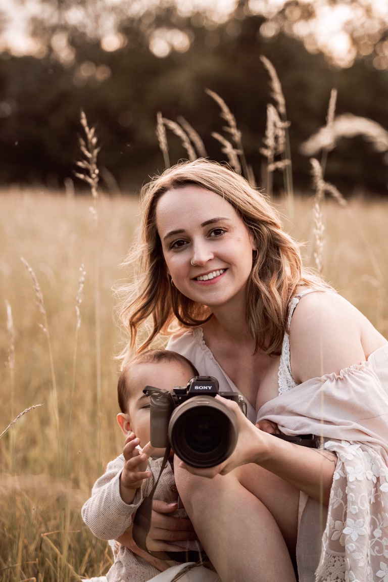 Verena mit Kind und Kamera in einer Wiese